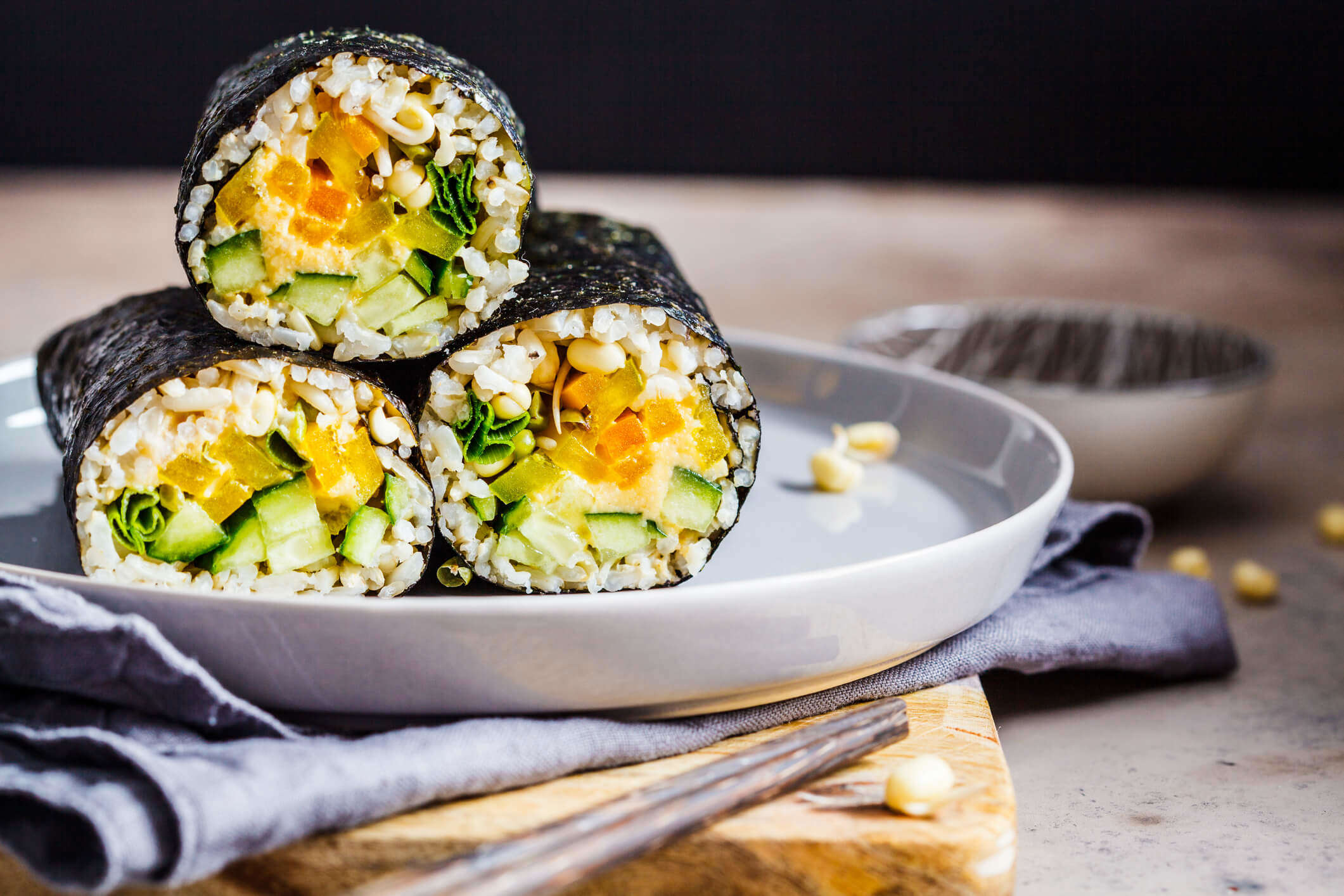 a close up of three vegan sushi rolls on a plate