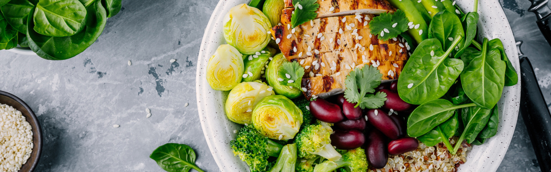 a chicken salad with kidney beans, Brussel sprouts, quinoa, spinach and sesame seeds