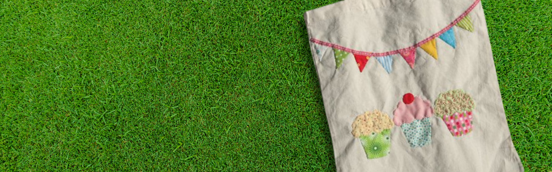 Main image: a DIY decorated tote bag, with fabric cupcakes and bunting, lay out on grass