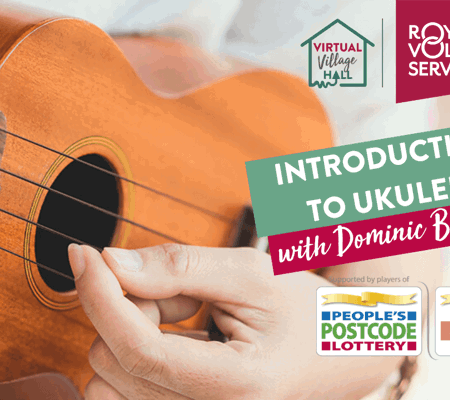 a close up of someone playing a wooden ukulele