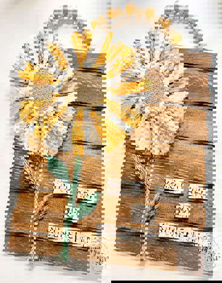 Main Image: a sunflower garden wall plaque - fabric flower on a wooden plaque with alphabet tiles that read "YOU ARE MY SUNSHINE"