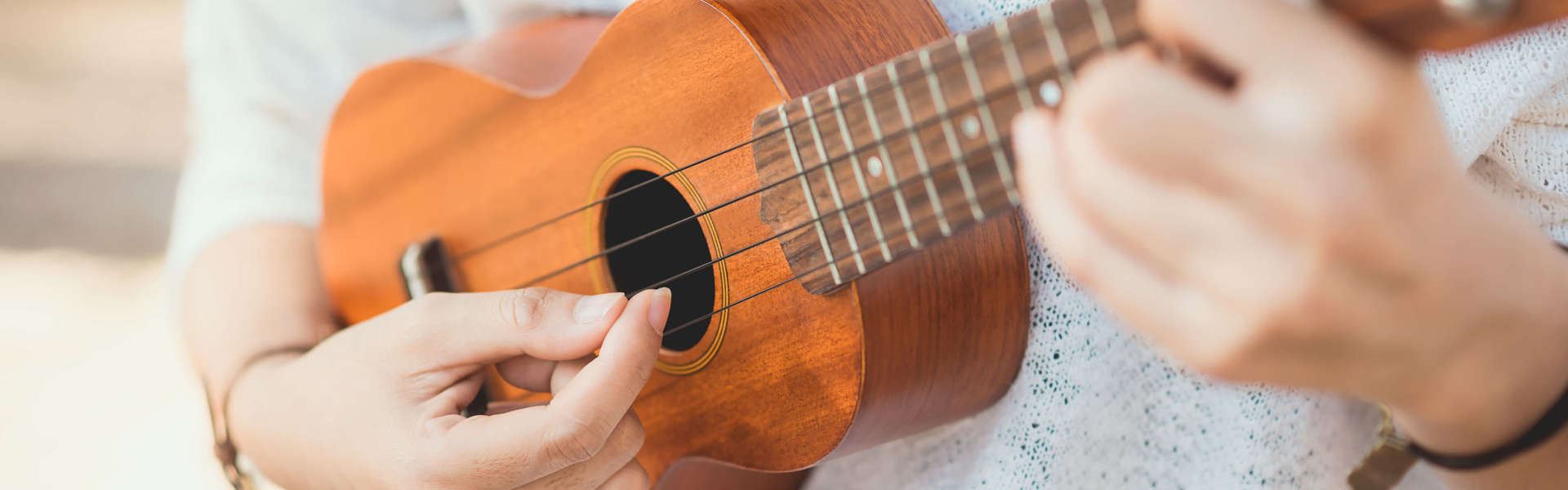 a close up of someone playing the ukulele