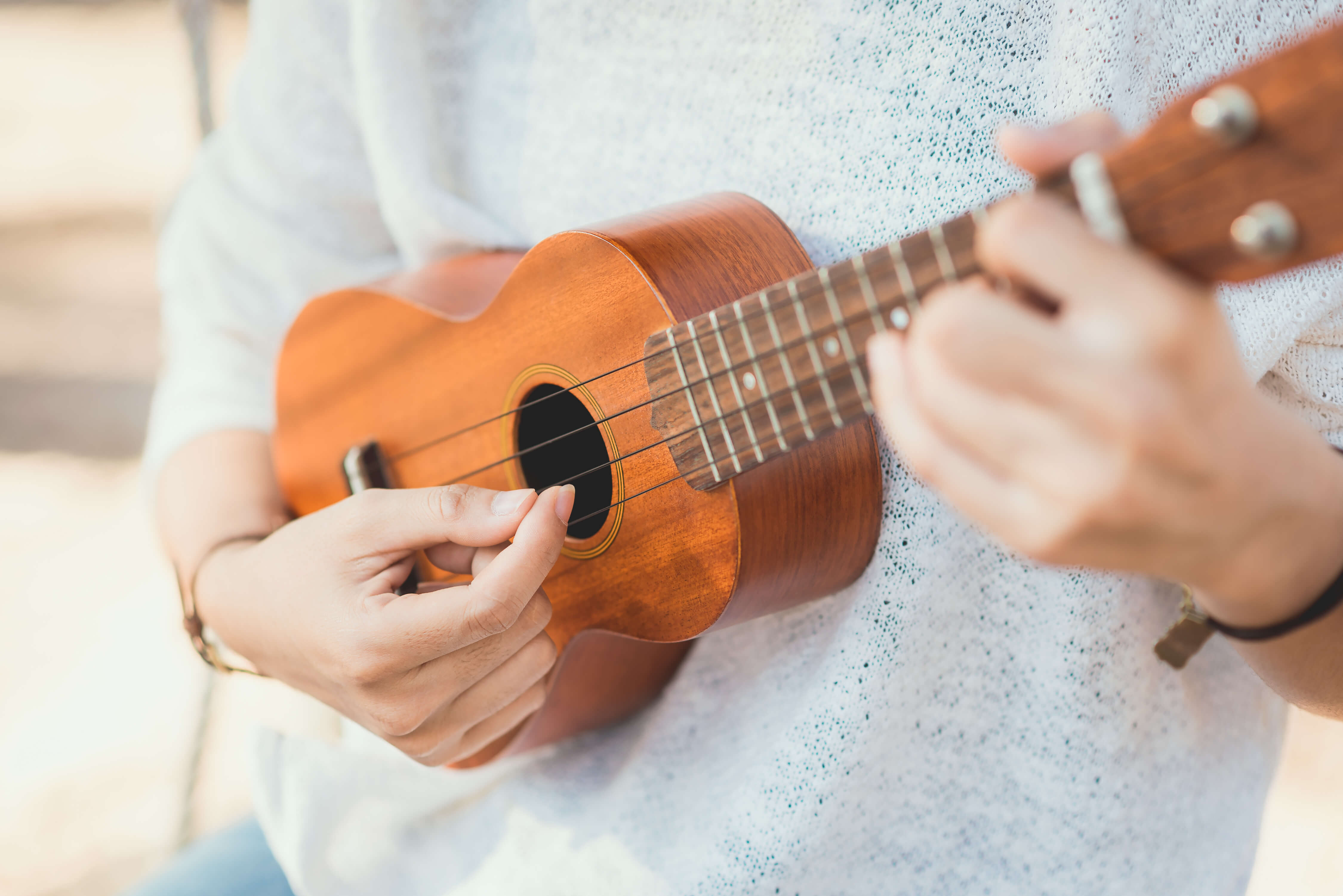 a close up of someone playing the ukulele