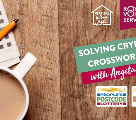 An ariel shot of a wooden table with a cup of tea on it next to a crossword puzzle and orange pen