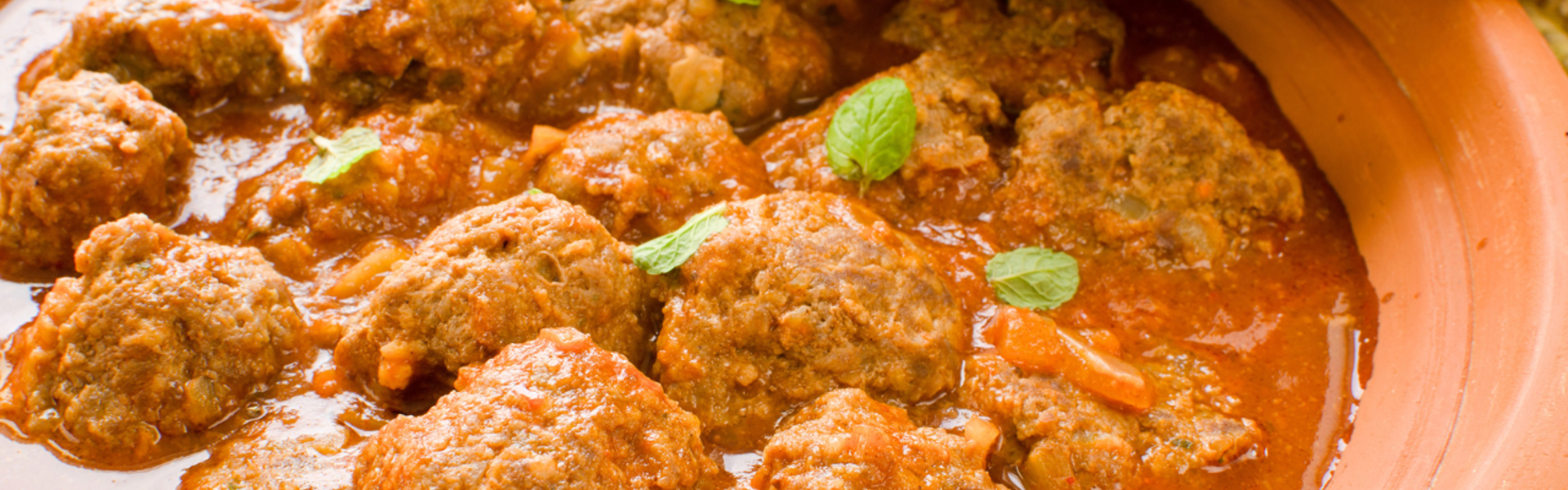Main image: meatball tagine with lemon, in a terracotta tagine pot.