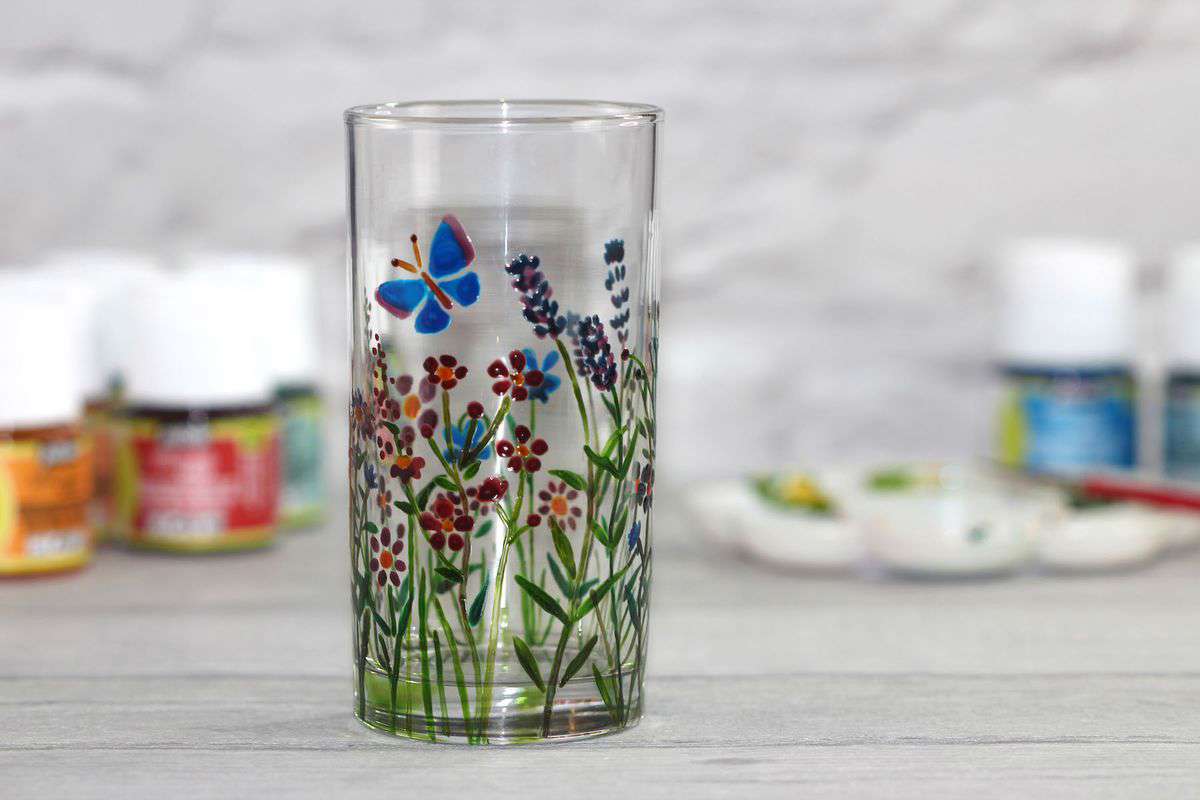 Main image: hand painted floral design with a blue butterfly from Kate's painting on glassware for beginners session.