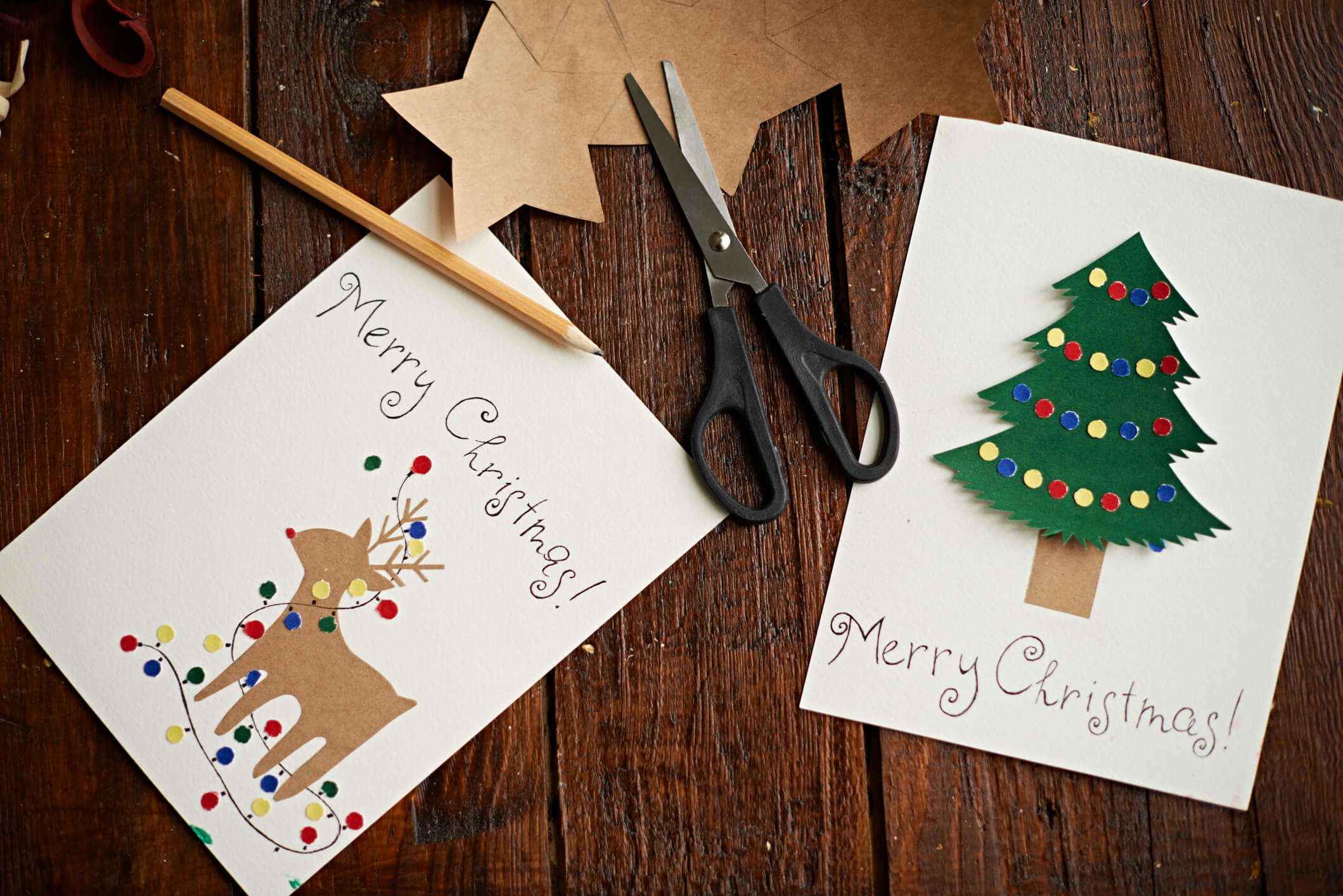 two recycled Christmas cards on a wooden table