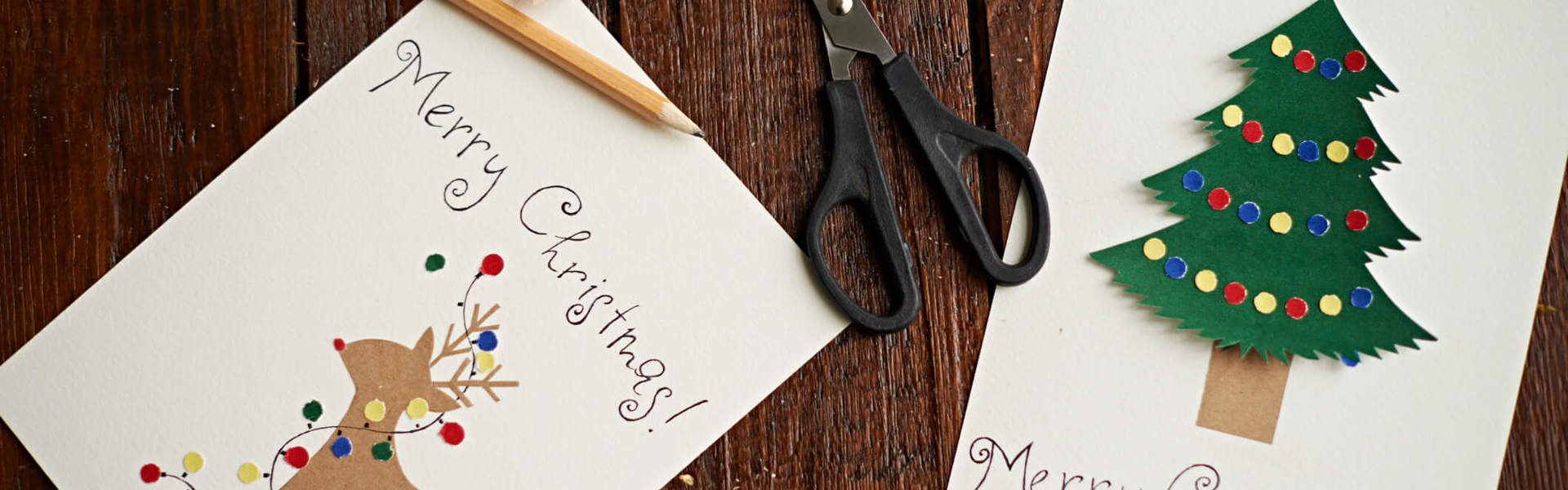 two recycled Christmas cards on a wooden table