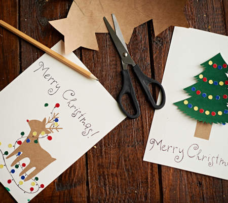 two recycled Christmas cards on a wooden table