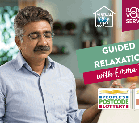 A man sat at a desk with his laptop open meditating