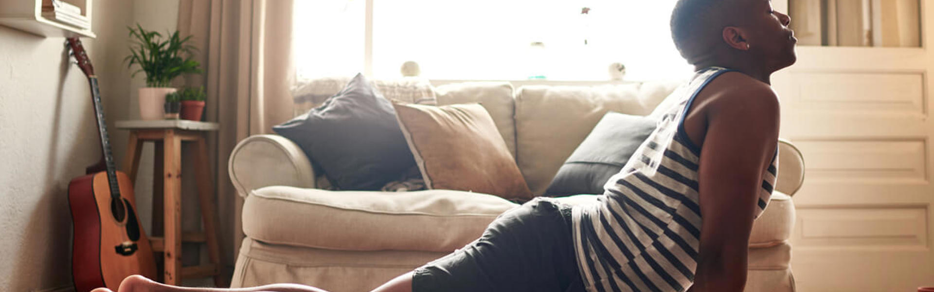 a man doing cobra pose on a yoga mat at home in the living room