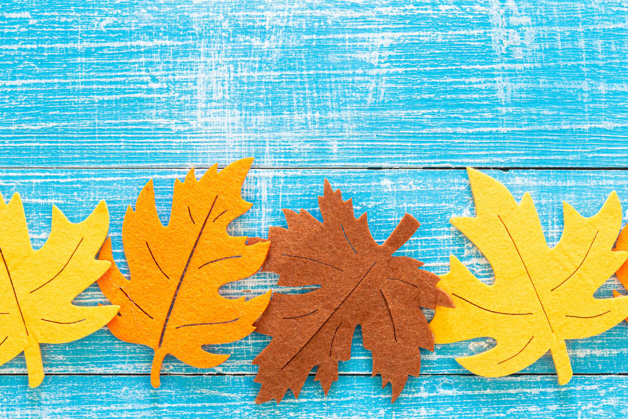 felt autumnal leaves on a blue wooden background