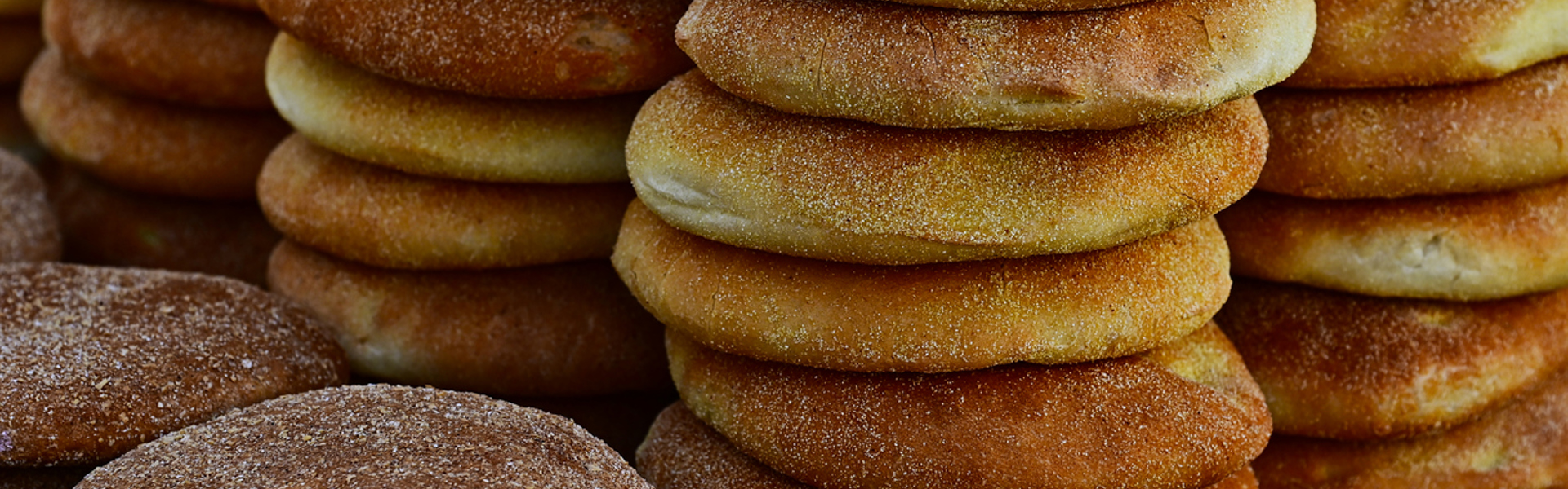 multiple stacks of baked flatbreads dusted with flour