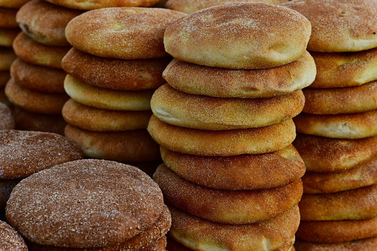 multiple stacks of baked flatbreads dusted with flour