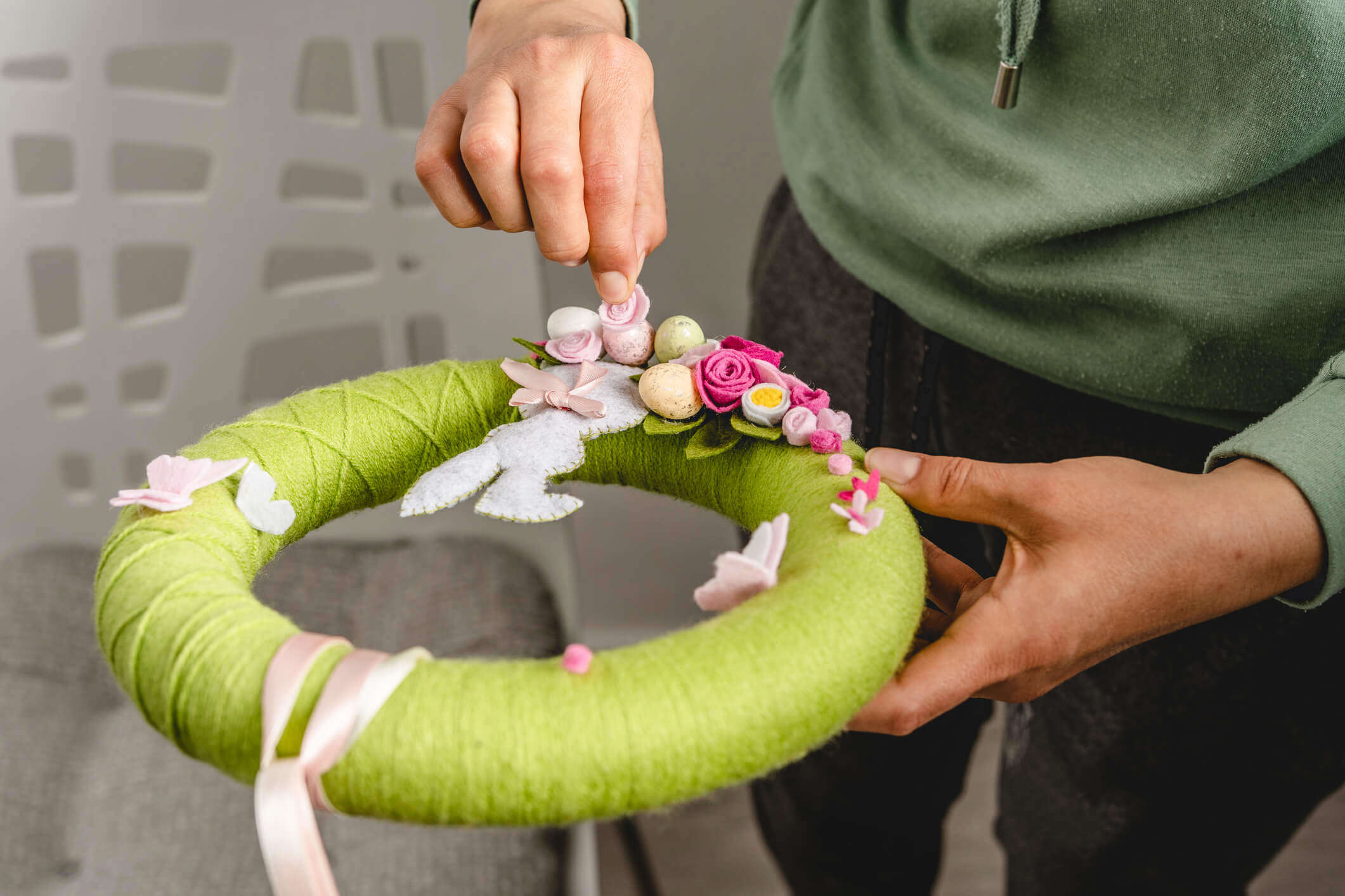 a green felt spring wreath featuring Easter themed felt decorations