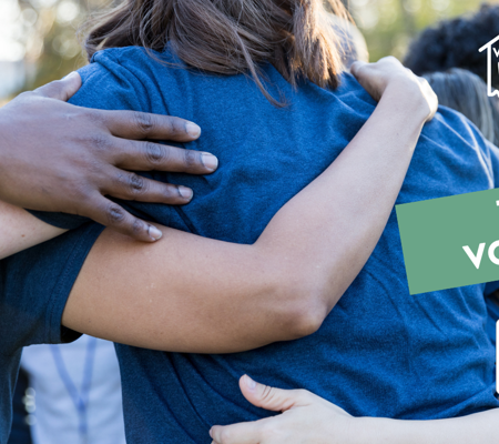 a photo of a group of people wearing blue t-shirts linked arm in arm
