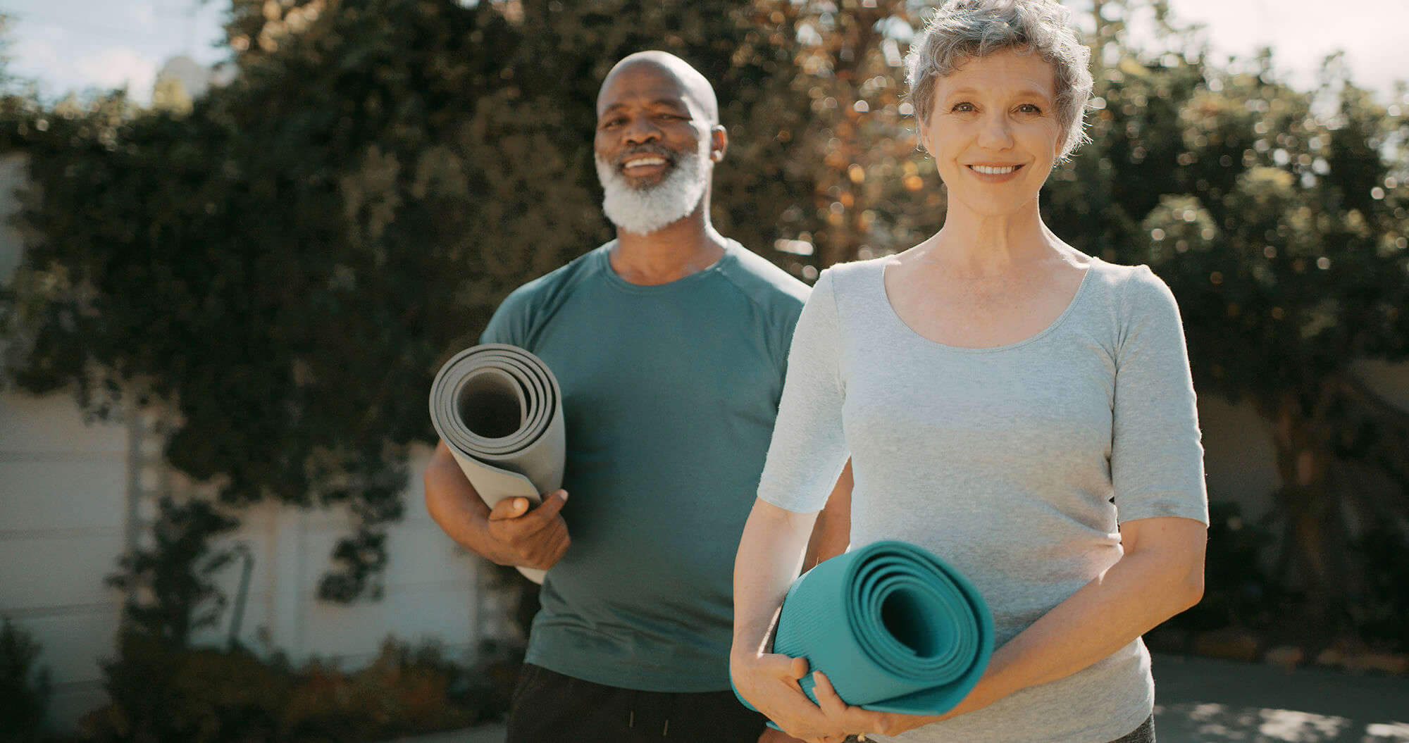 A couple carrying yoga mats