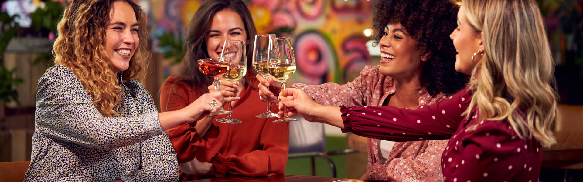 a group of friends on a night out toasting with drinks