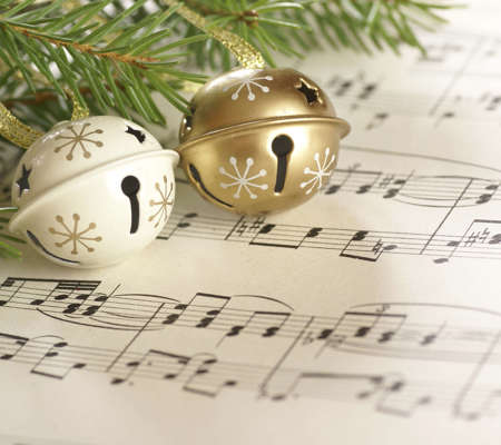 two Christmas bells on a sheet of music 