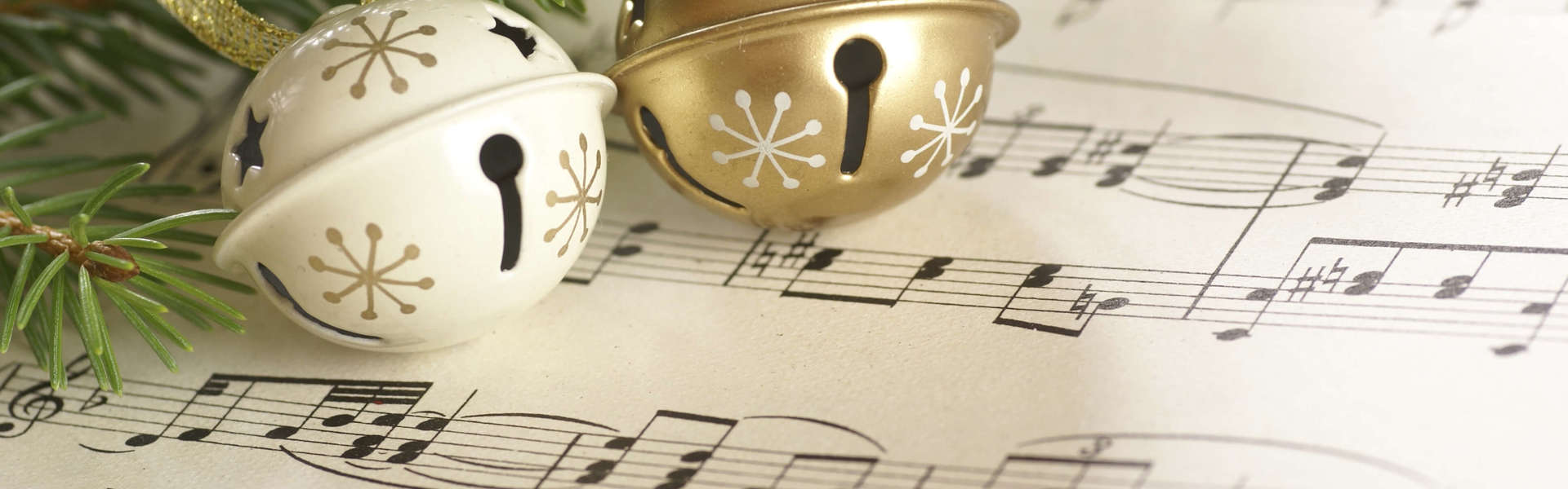 two Christmas bells on a sheet of music