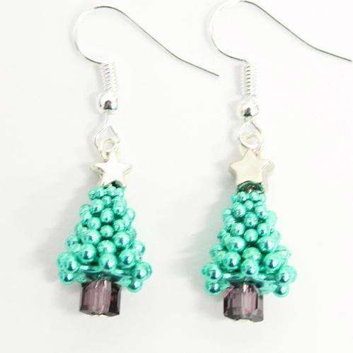 A close up of a pair of two green festive Christmas tree earrings