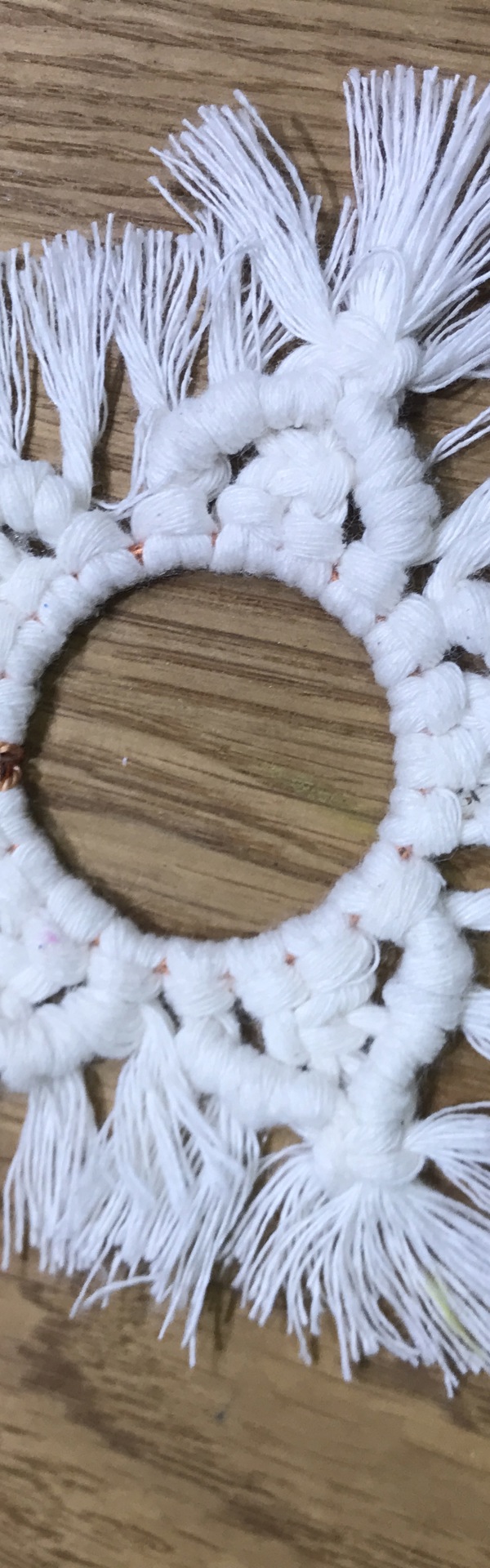 A handmade white macramé star on a wooden table