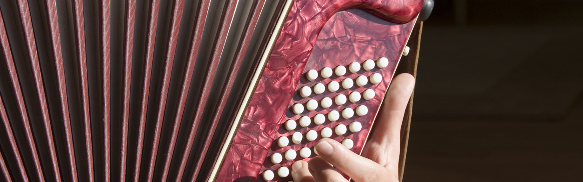 a close up of a red accordion being played on a black background