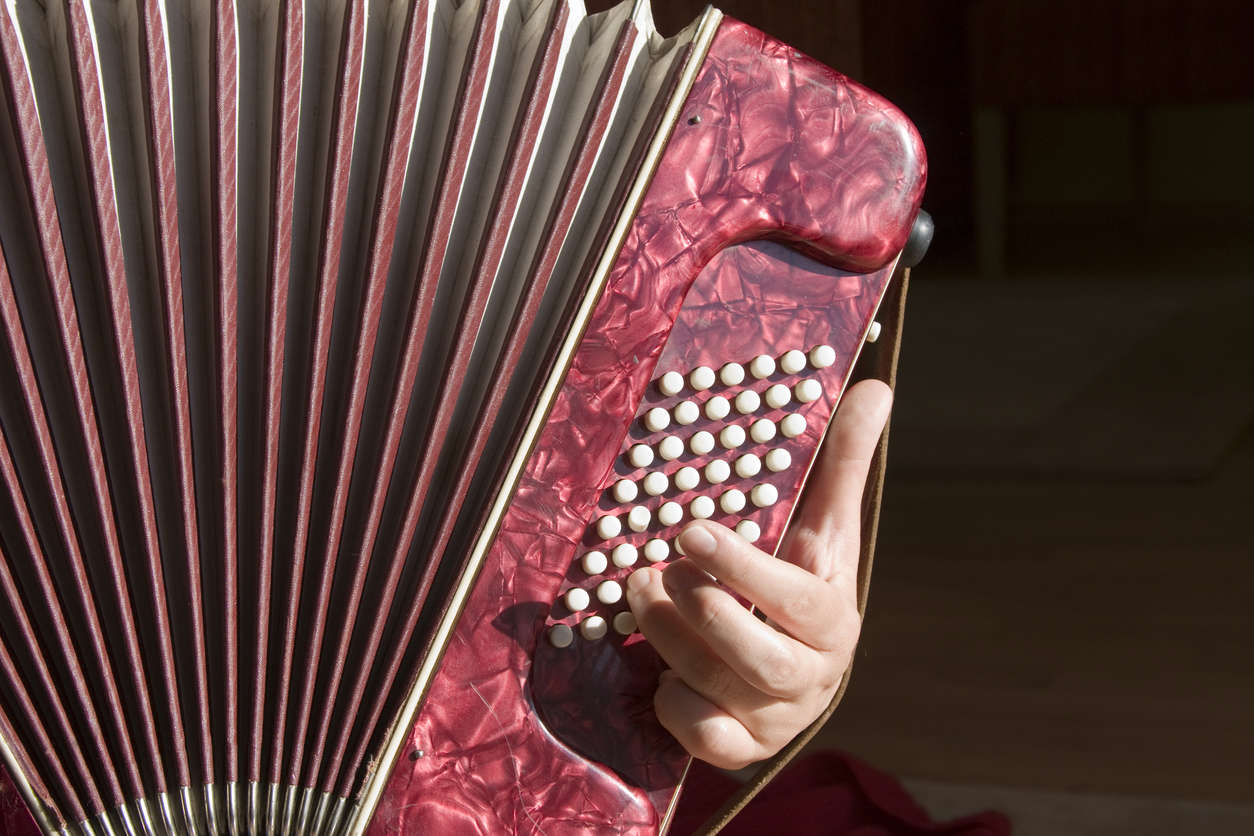 a close up of a red accordion being played on a black background