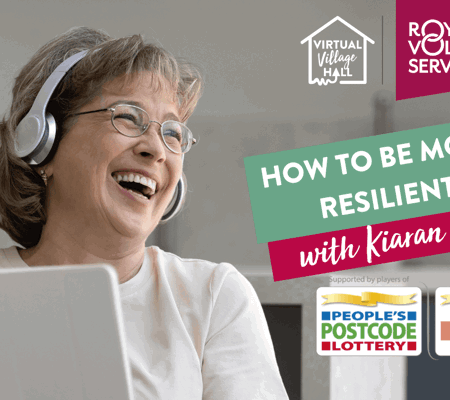 A woman holding an ipad and wearing headphones whilst laughing