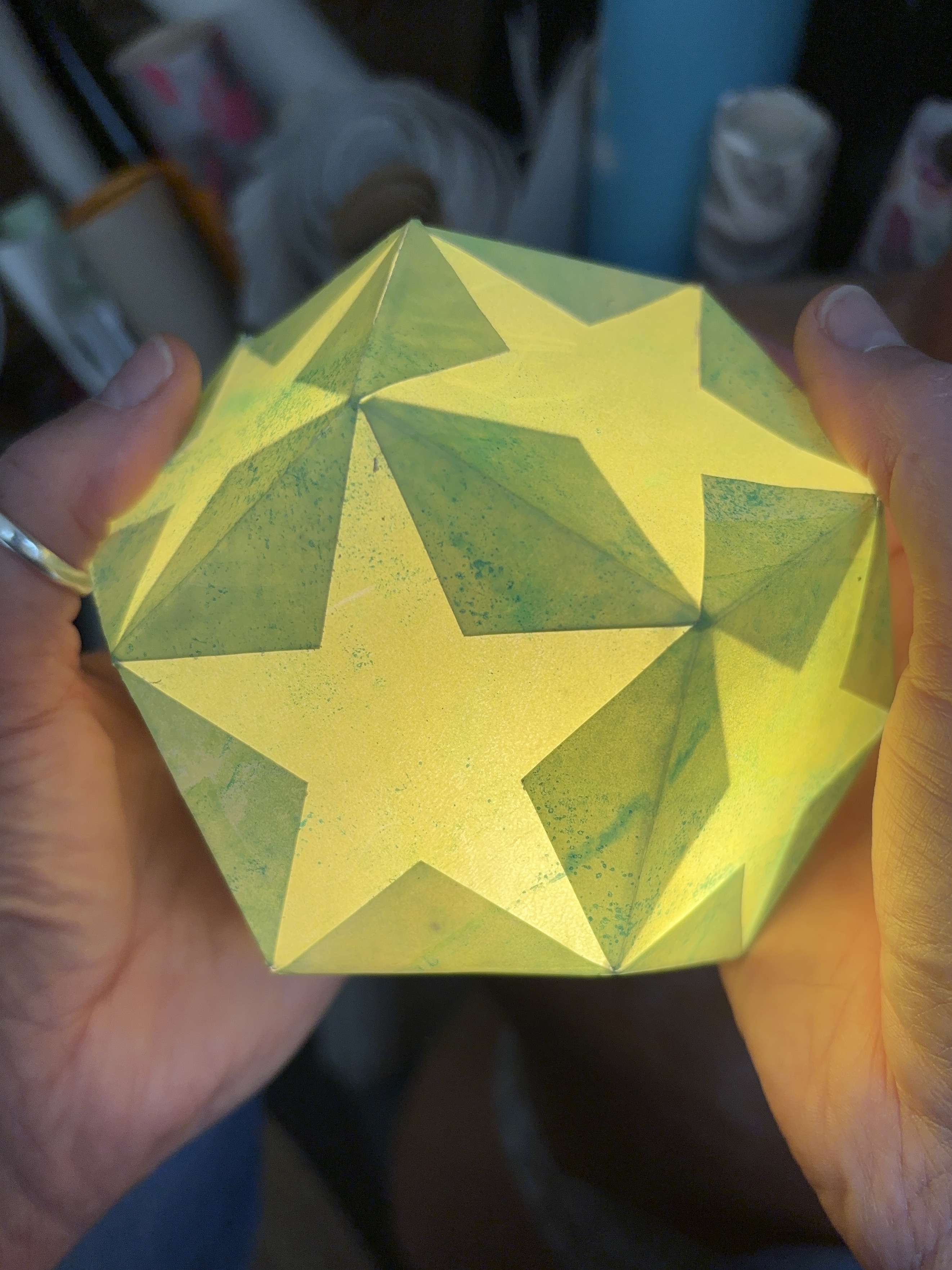 a close up of a green and yellow printed paper lantern made by Rachel Moore