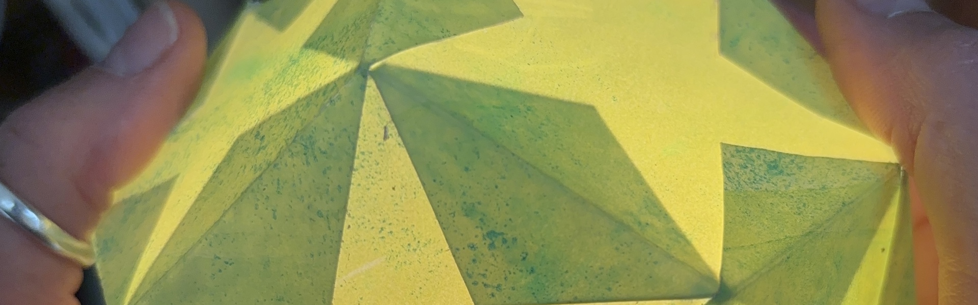 a close up of a green and yellow printed paper lantern made by Rachel Moore