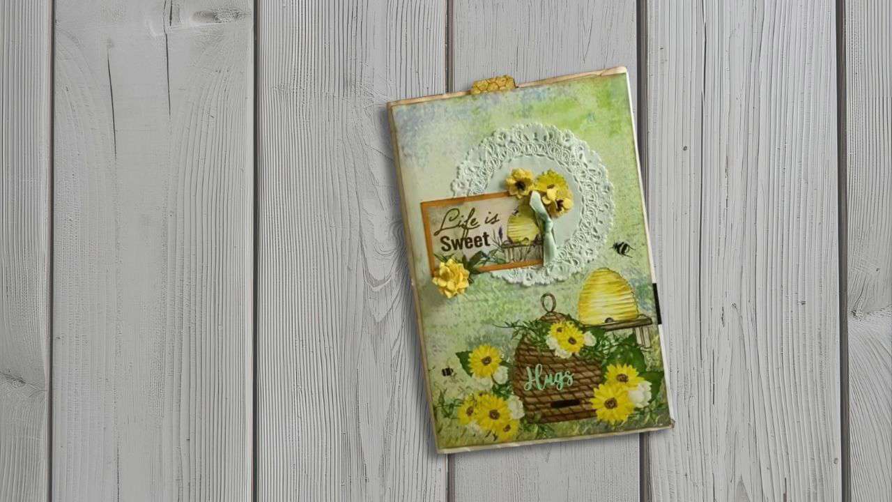 Main image: a DIY pencil case/stationery pouch, made using upcycled junk mail, ribbons and fake flowers. With a beehive and 'life is sweet' moto. 