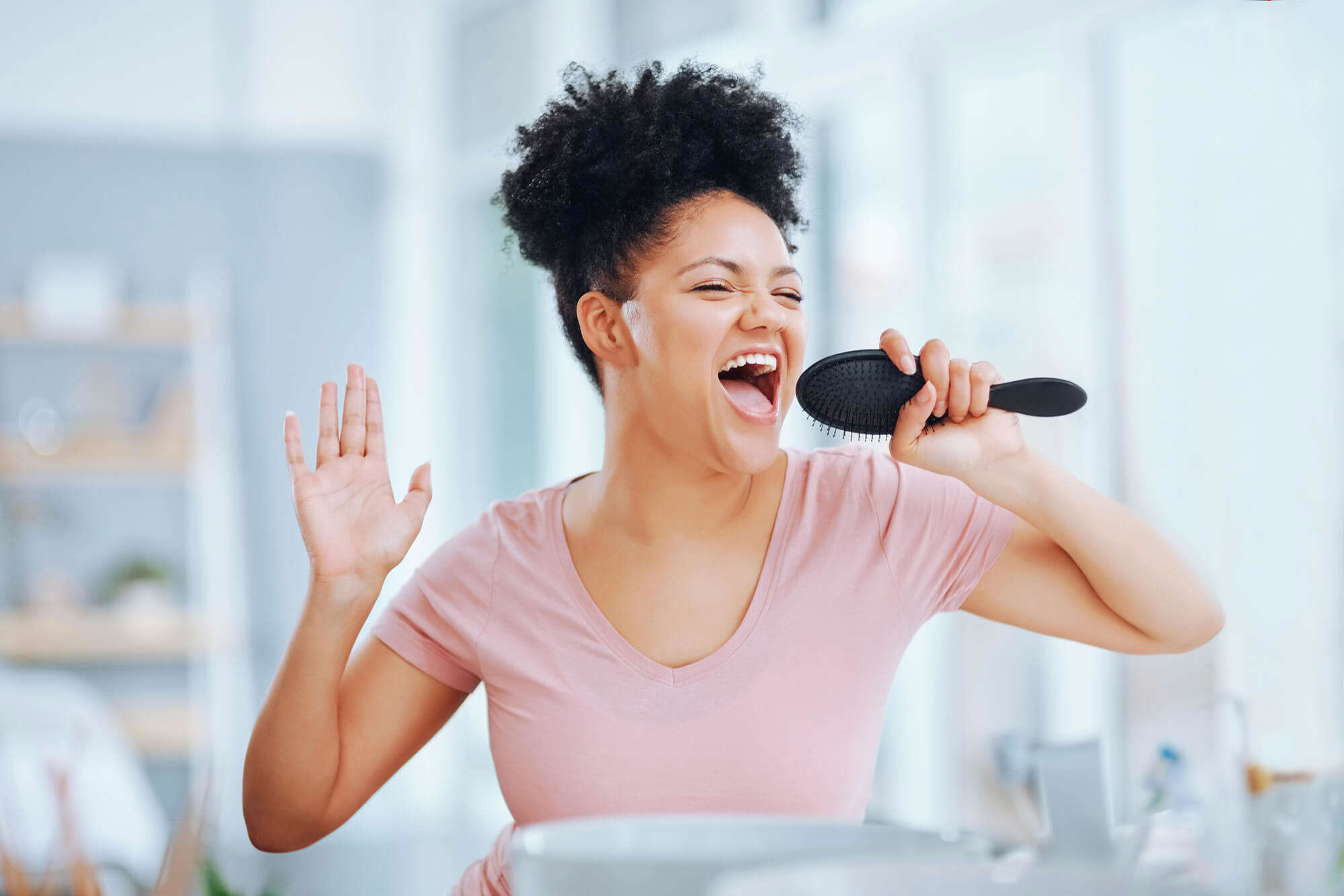 A woman singing into a hair brush