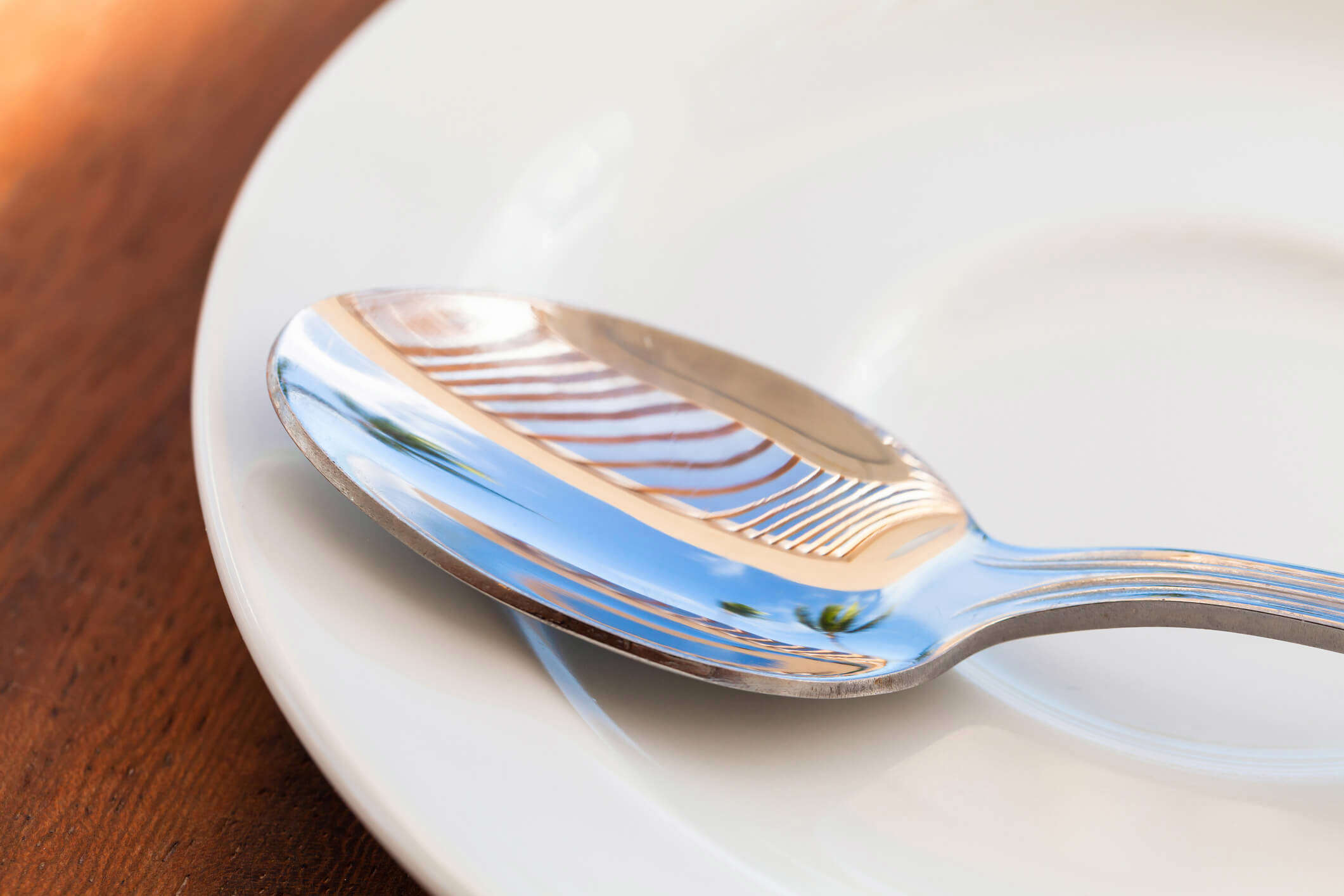 a close up of a spoon reflecting the surroundings