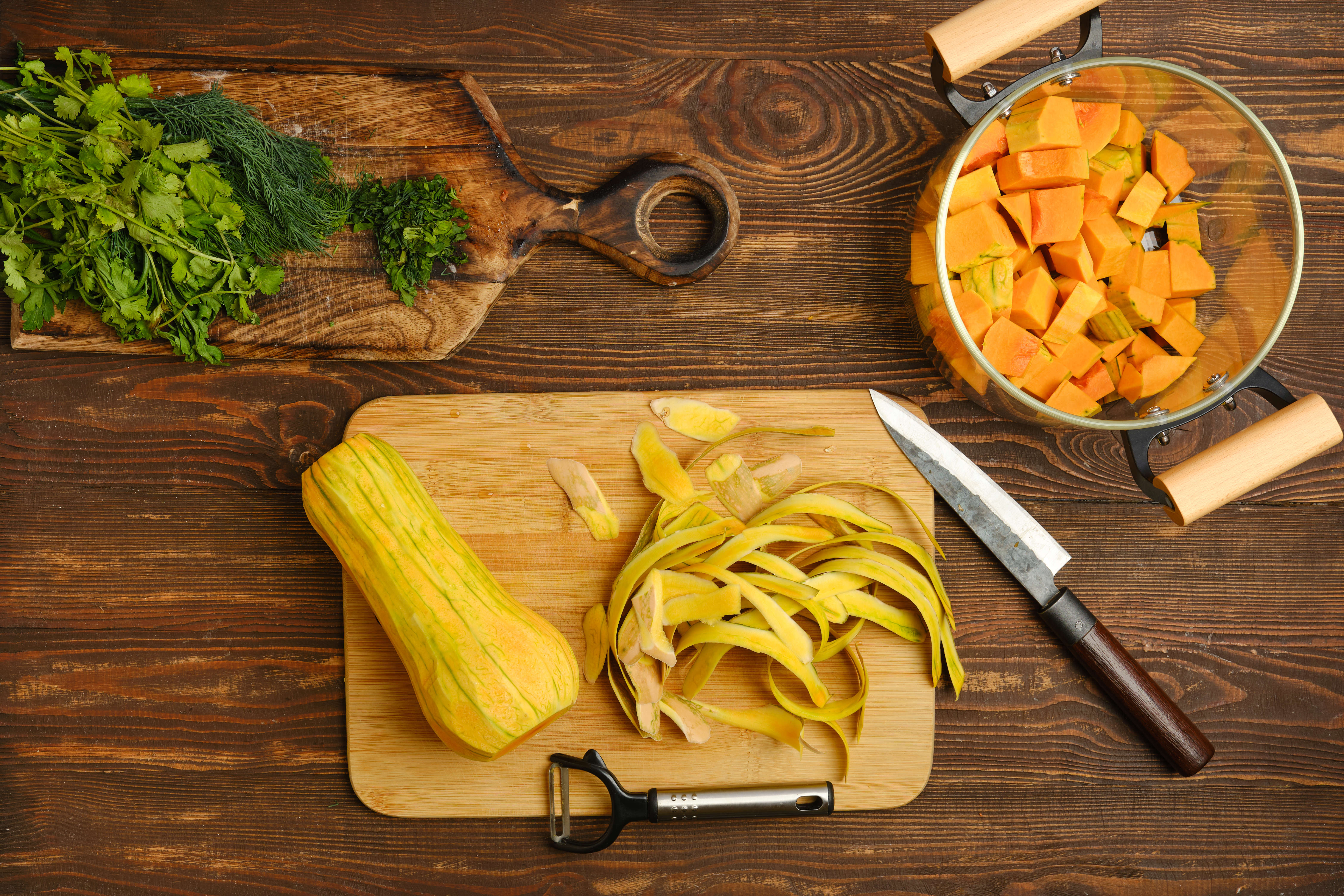 Main image: a butternut squash peeled and chopped along with other ingredients to make butternut squash curry.