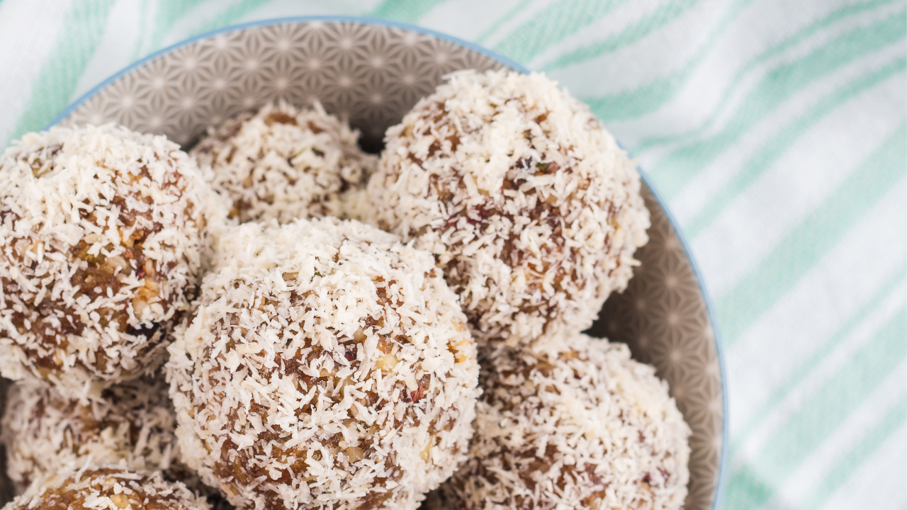 No Bake Date Energy Balls in a bowl on a white and green striped table cloth.