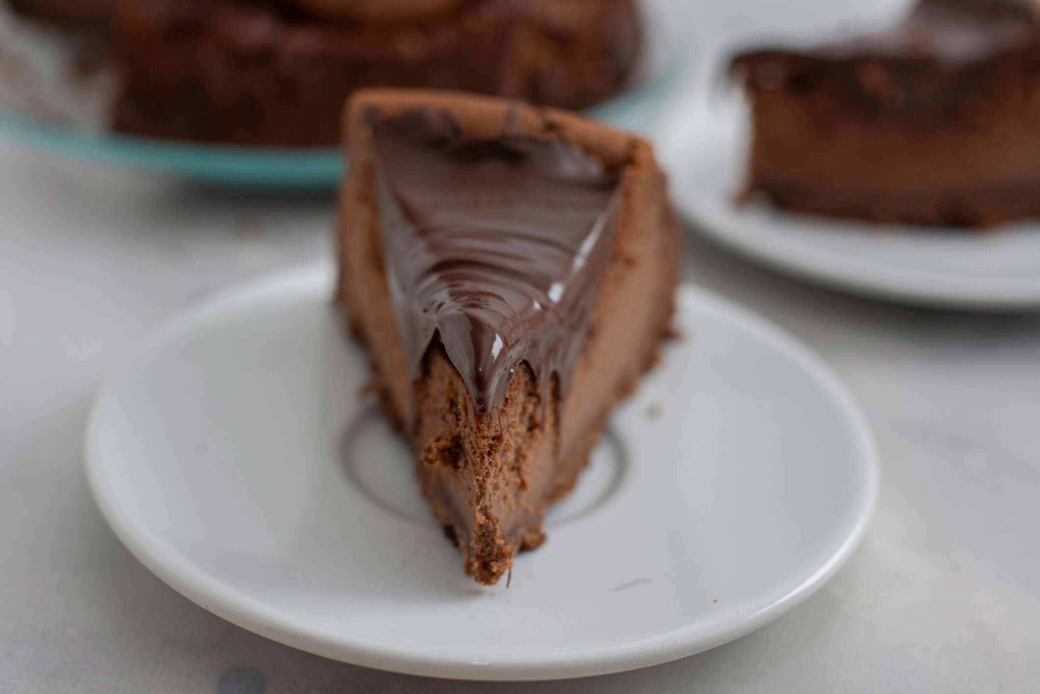 A slice of chocolate cheesecake on a white plate