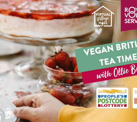 a traditional English afternoon tea table spread with a teacup and saucer, a strawberry cake and pot of fresh strawberries