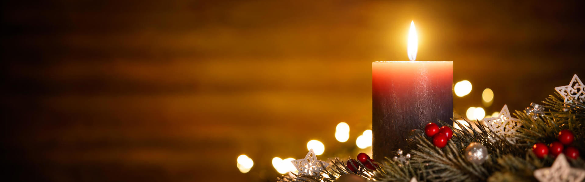 a brown Christmas candle surrounded by Christmas festive decoartions