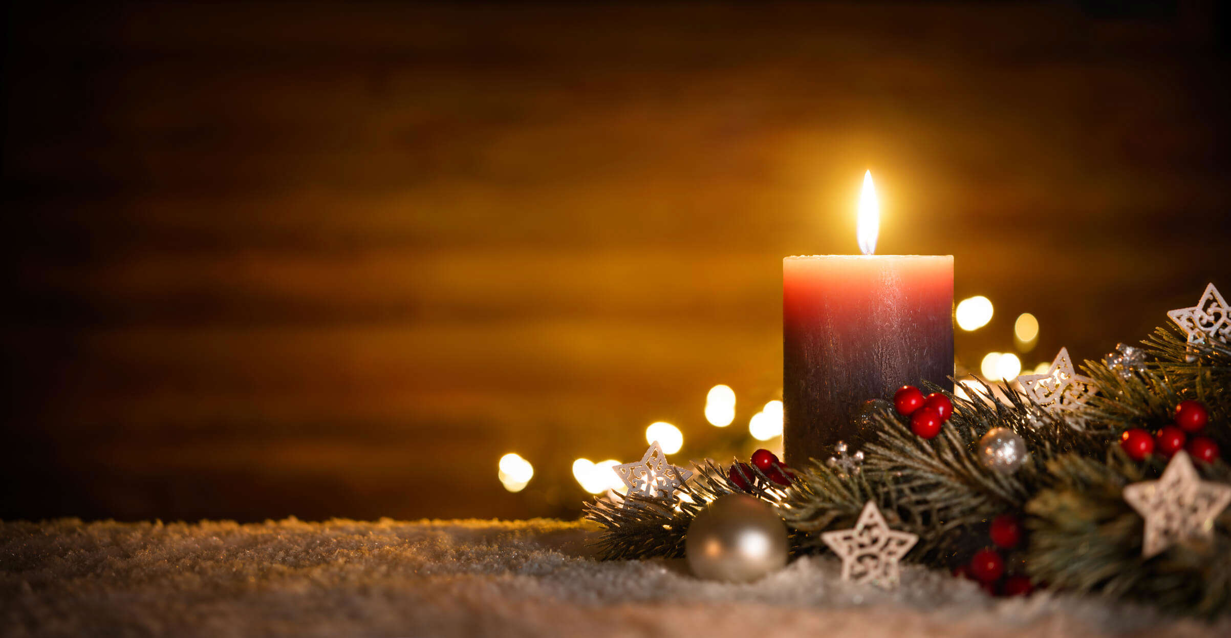 a brown Christmas candle surrounded by Christmas festive decoartions