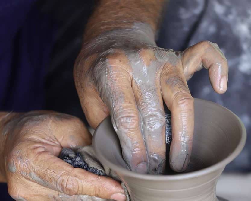 a pair of hands throwing clay