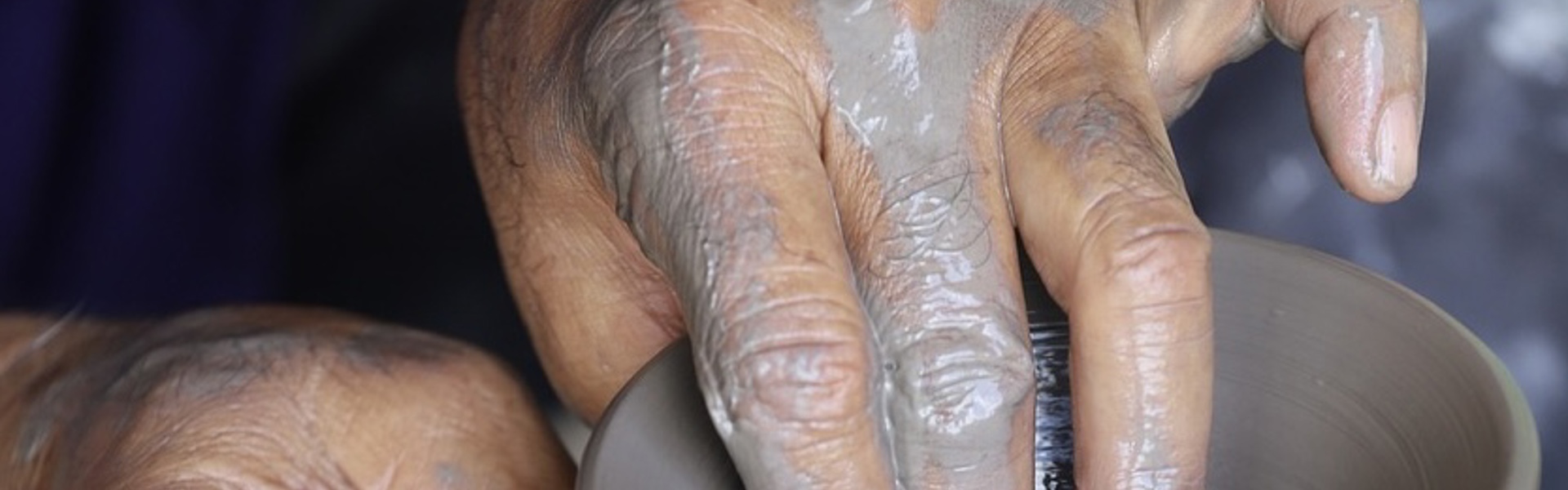 a pair of hands throwing clay