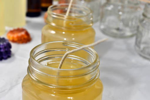 a close up of handmade candles with wax and a wick