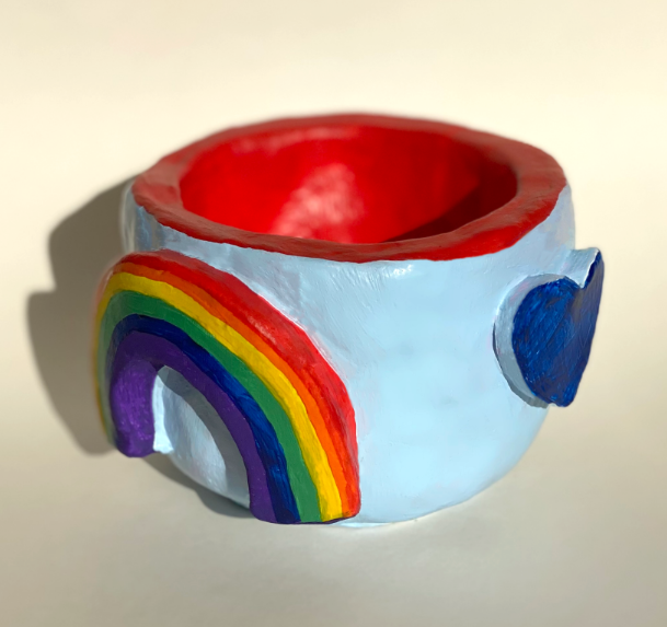 a small blue Pride themed clay pinch pot decorated with rainbows and rainbow hearts made by Olivia Hardman