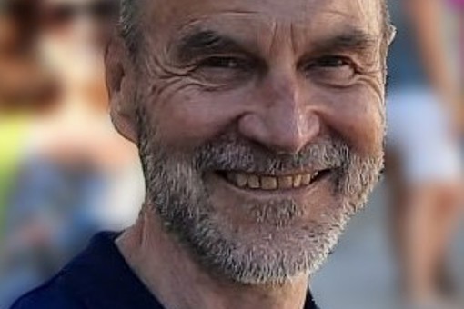 A headshot photo of Dr Roger Greene, Chief Director for AtaLoss bereavement charity, wearing a dark blue shirt smiling at the camera.