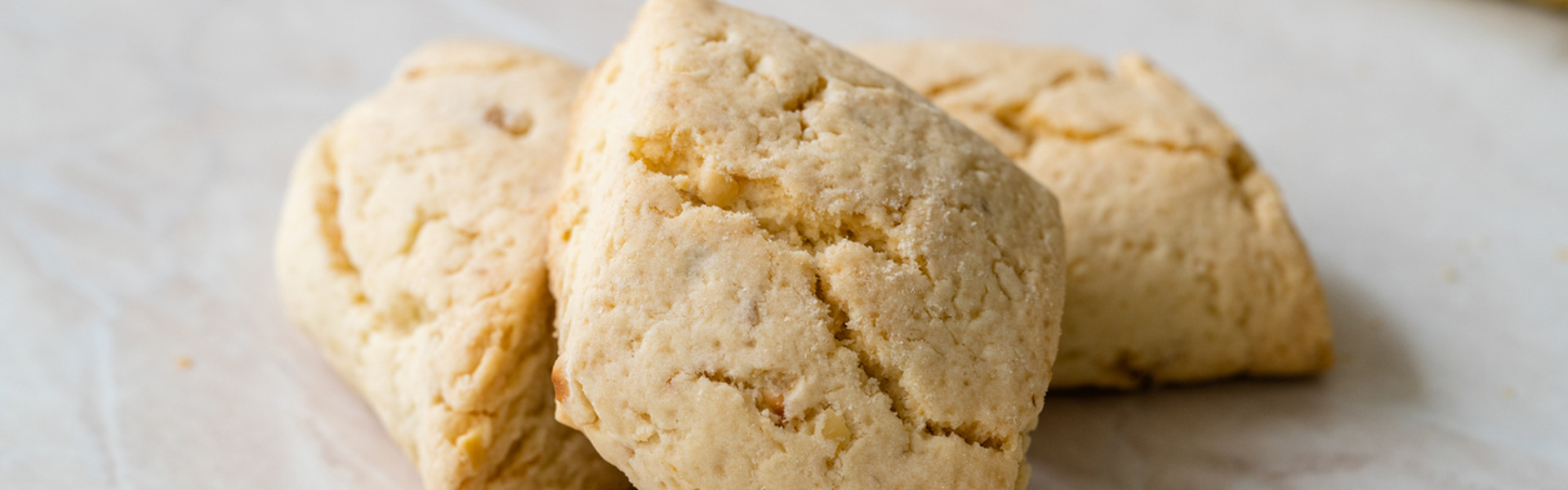 Three freshly baked shortbread biscuits on a white background