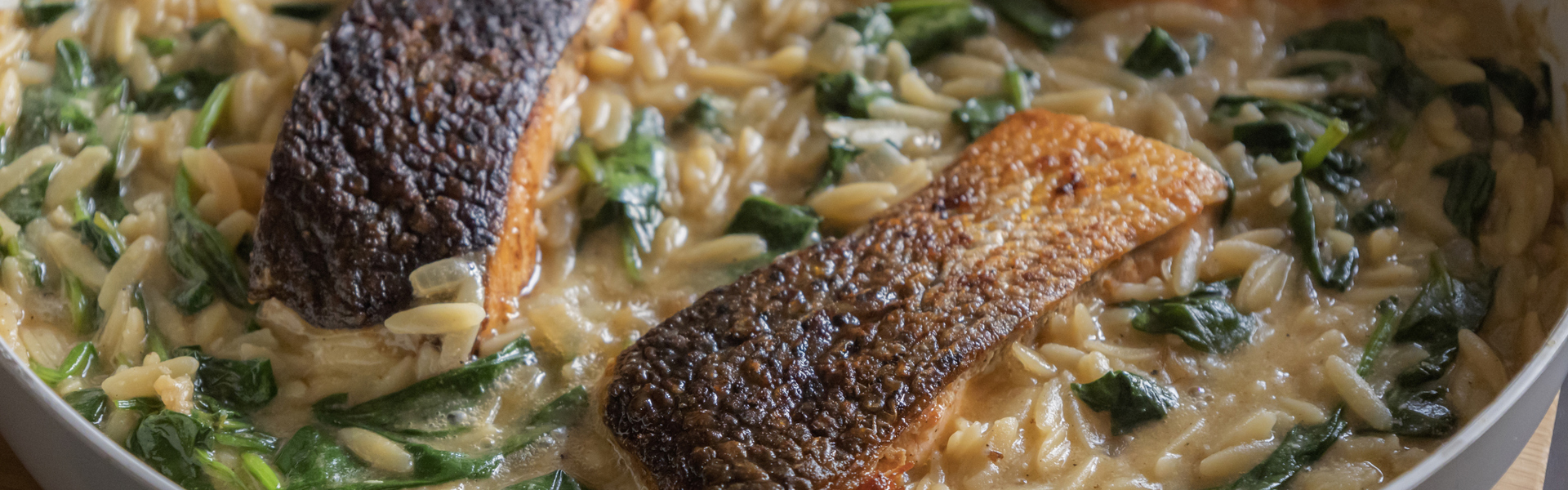 Main image: up close image of a summer salmon and orzo pesto salad in a grey bowl.