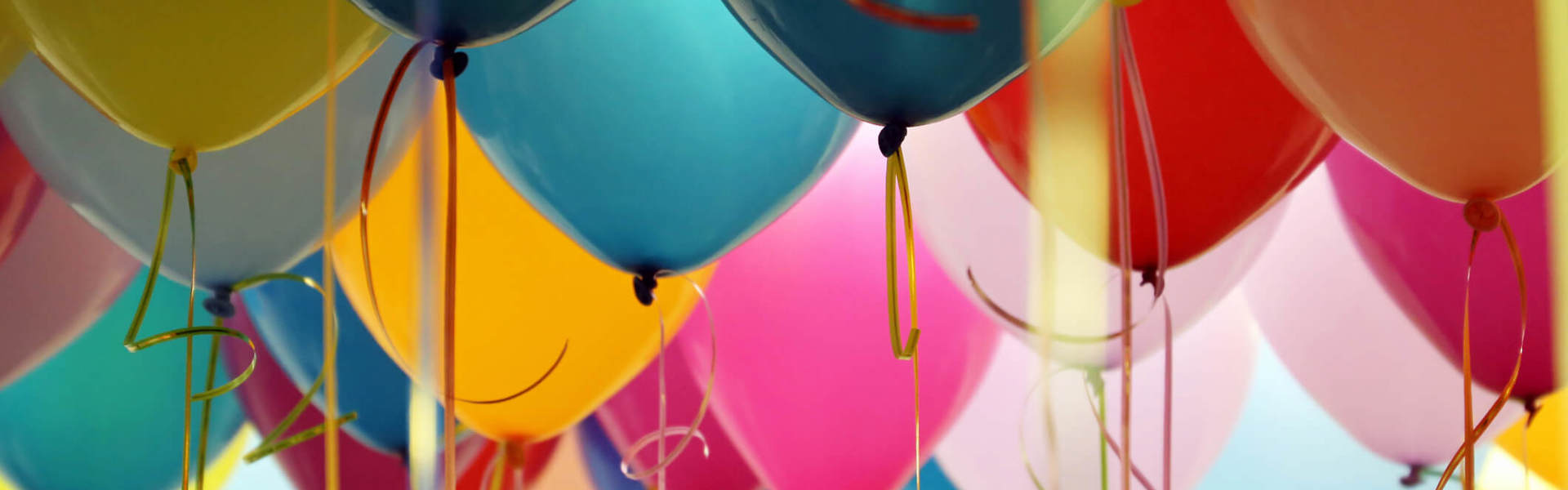 multicoloured birthday balloons floating in the air