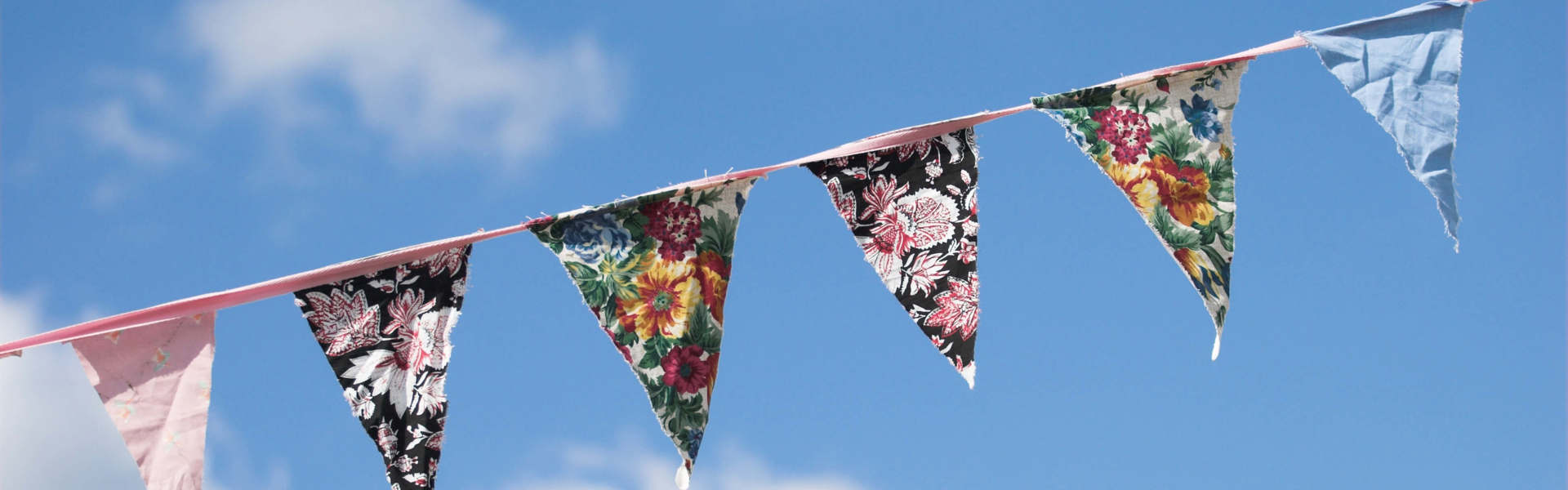 hand sewn vintage tea party bunting against a blue sky backdrop