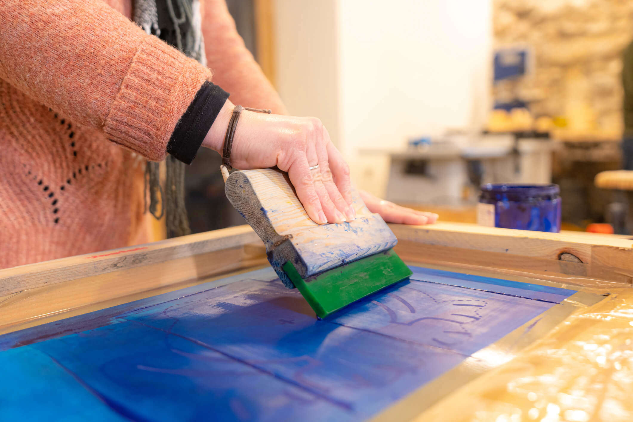 A close up of someone screen printing